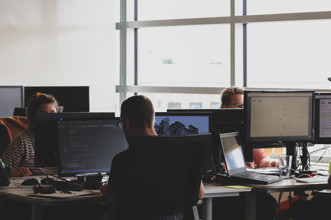 Colleagues gathered around a computer monitor working together